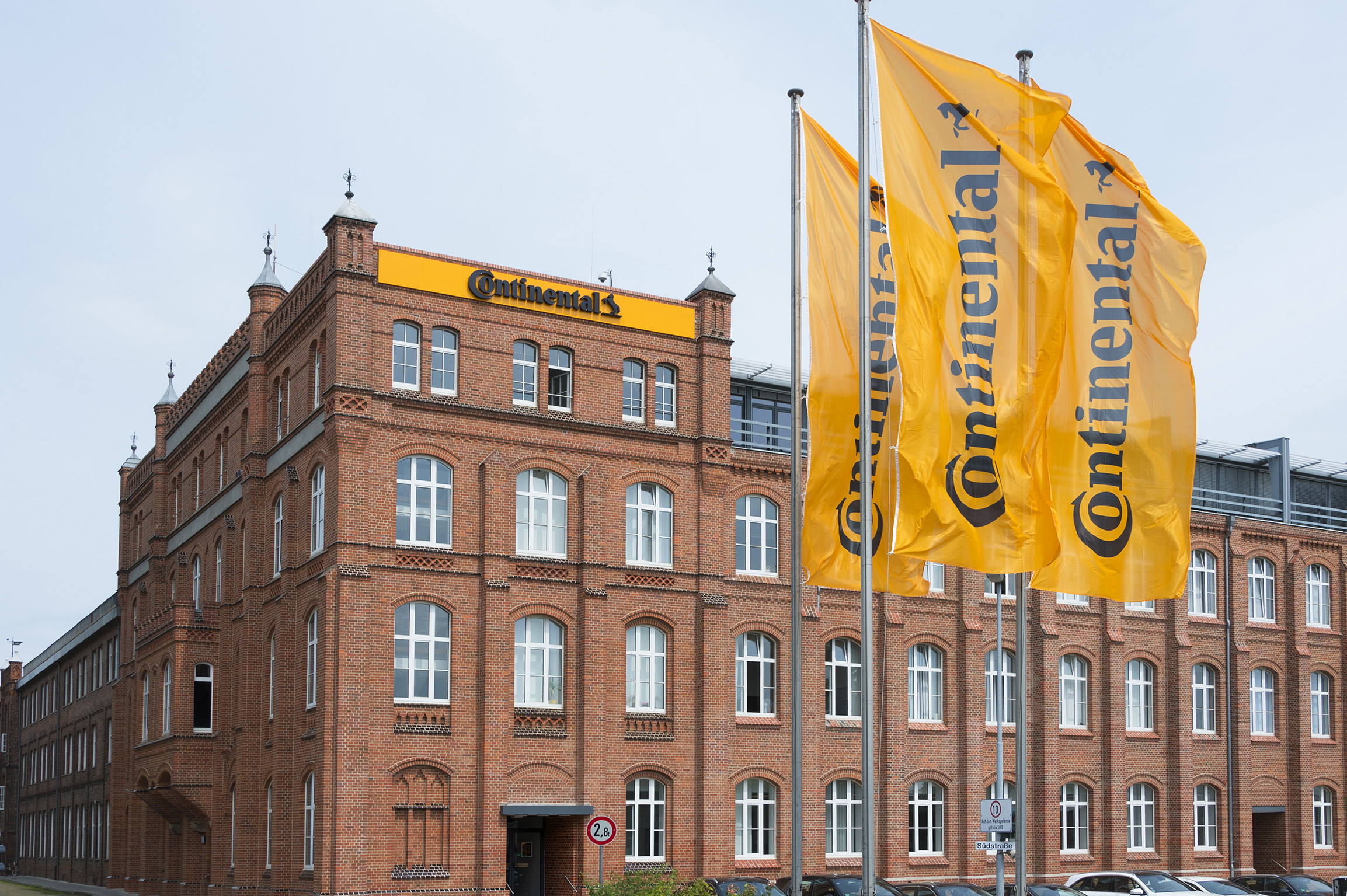 The Continental factory building in Hannover with yellow flags bearing the company logo, showcasing the site where the recent explosion occurred